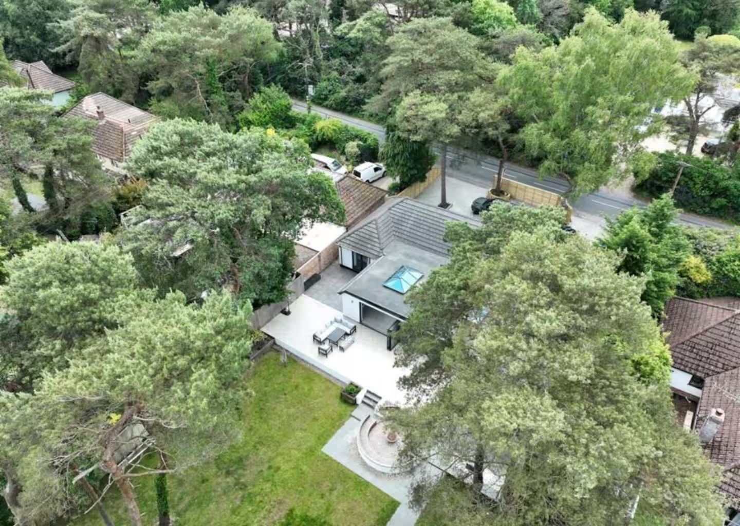 Aerial view of Kiwi Pines and its garden, surrounded by tall pine trees